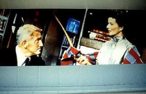 Details. The video monitor is embedded in the book case between Spencer Tracy (L) and Katharine Hepburn (R), here seen in a scene from the movie "Desk Set."